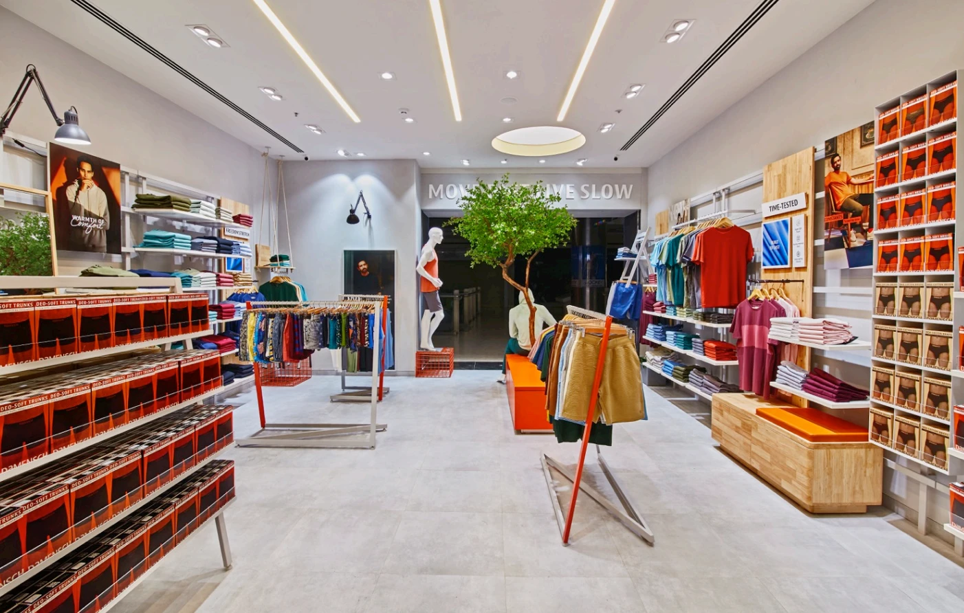 Clothing store with orange shelving and central garment displays, Mustardd Spaces interior design portfolio