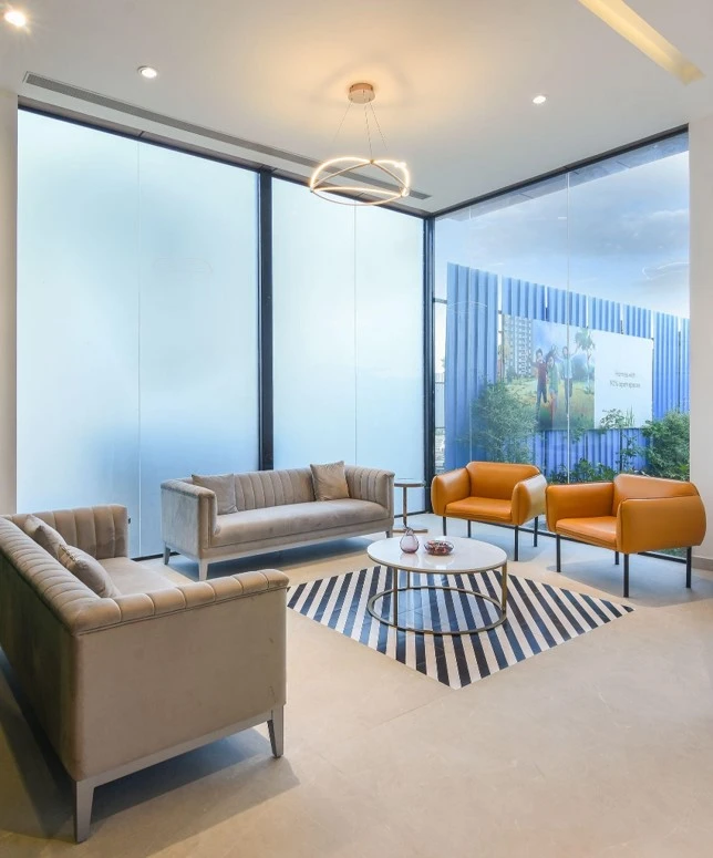 Reception lounge with sofas and large windows, commercial interior design in Raipur