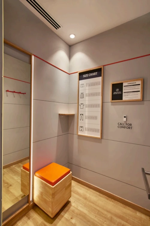 Retail fitting room with a bench and full-height mirror, Mustardd Spaces interior design portfolio