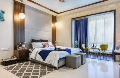 Bedroom with a padded headboard and blue curtains, Mustardd Spaces interior design portfolio