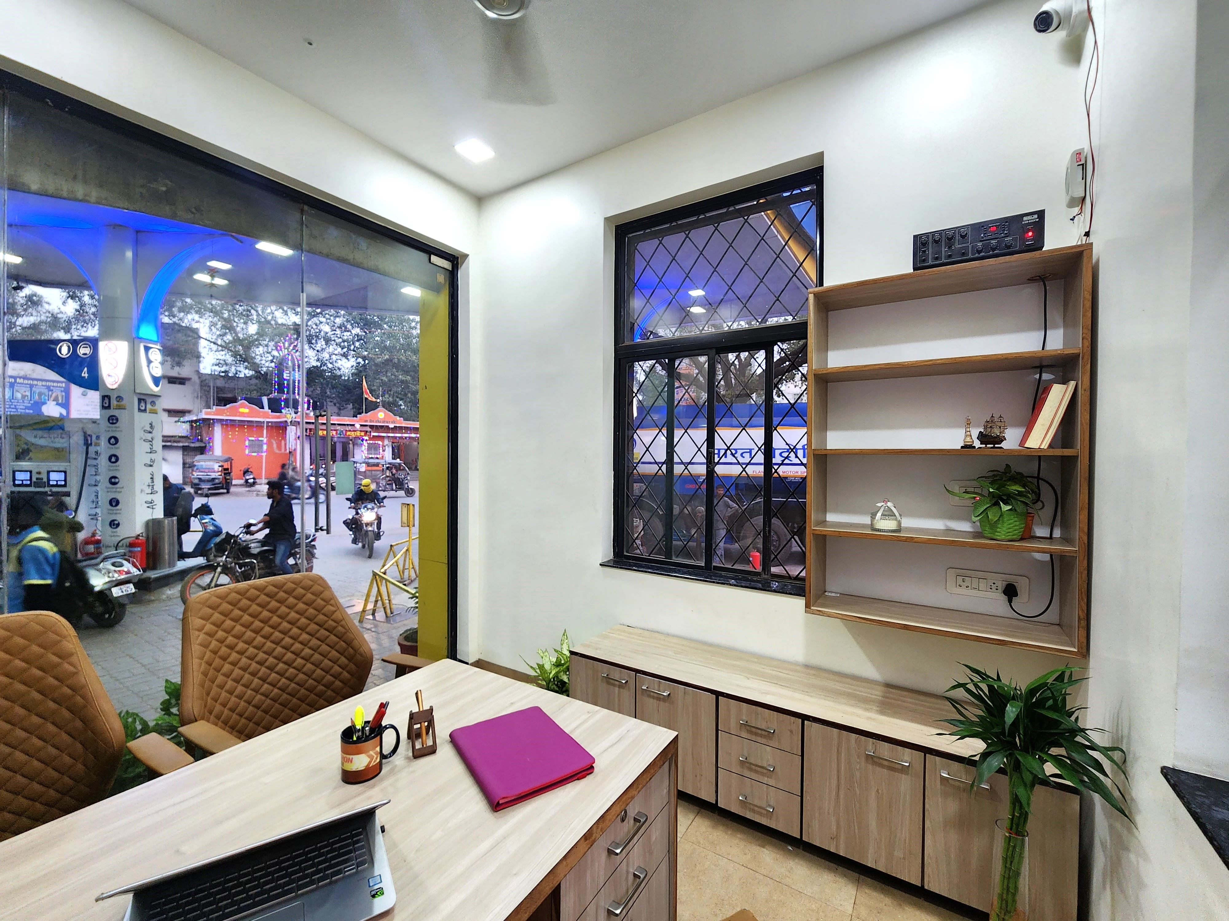 Office desk beside a window and illuminated display shelving, The Office turnkey office interior design in Bhilai by Mustardd Spaces